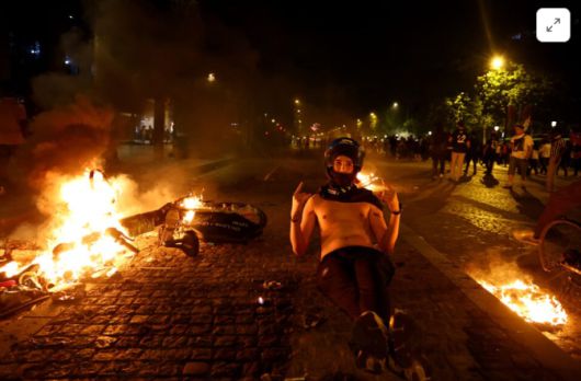 한 시민이 불길 속에서 포즈를 취하고 있다. [사진 = 로이터]