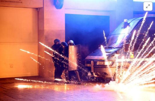 경찰이 소요사태 현장에서 몸을 피하고 있다. [사진 = 로이터]