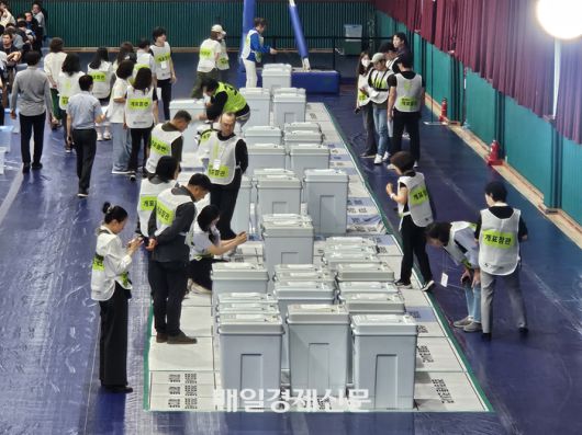 지난 3일 저녁 8시 35분께 참관인들이 개표소로 이동된 투표함의 상태를 개함하기 전에 확인하고 있다. [사진 지혜진 기자]