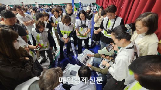 지난 4일 새벽 1시께 부정선거방지대에서 나온 개표참관인들이 본인들이 찍어놓은 사전투표함 봉인지 사진과 개표소에 도착한 투표함 봉인지 사진을 대조하며 이의를 제기하고 있다. [사진 지혜진 기자]