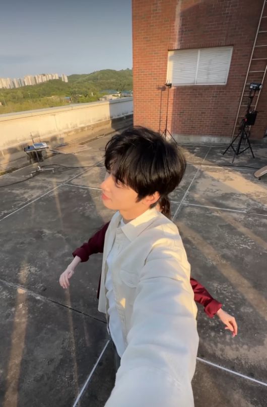 차은우는 아이보리 셔츠에 순수한 반응으로 퓨어한 매력을 보여주며 ‘뮤비보다 설레는 비하인드’라는 반응을 이끌었다.사진=아이유 공식 SNS