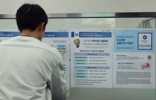 한 직장인이 퇴직연금 상품  소개 글을 읽고 있다. [사진 = 연합뉴스]