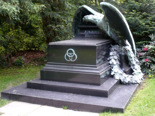 “여기 독일을 위대하게 만들고, 스스로 자멸한 남자가 잠들다.” 프리드리히 알프레드 크루프의 무덤. 크루프사를 상징하는 삼륜 조각이 붙어있다.