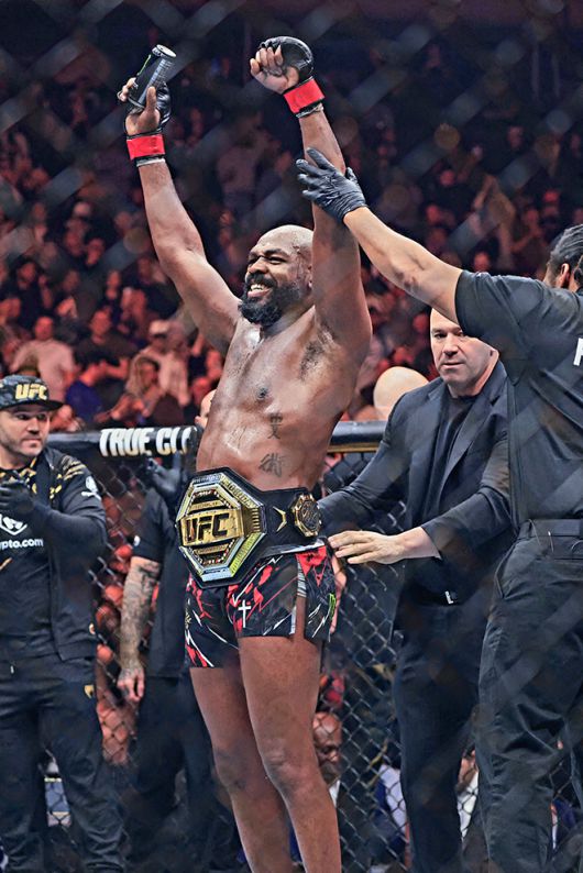 제23대 UFC 헤비급 챔피언 존 존스가 2024년 12월 미국 뉴욕 매디슨스퀘어가든에서 타이틀 1차 방어 성공 후 기뻐하고 있다. 오른쪽은 벨트를 채워주는 데이나 화이트 최고경영자 겸 회장. 사진=AFP=연합뉴스 제공