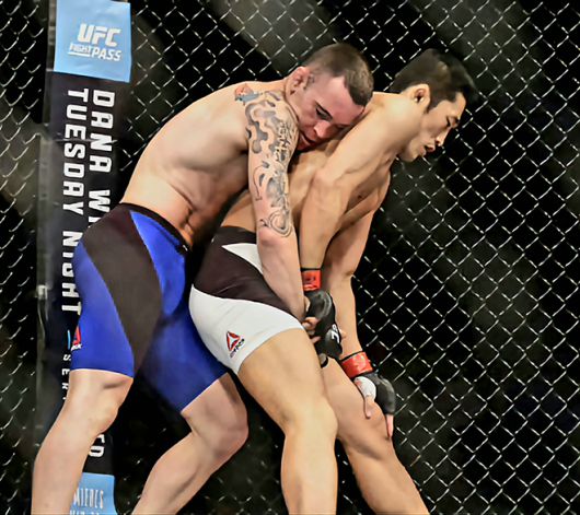 웰터급 6위 출신 김동현이 2017년 6월 싱가포르체육관 UFC 파이트 나이트 111에서 훗날 잠정 챔피언이 되는 콜비 코빙턴한테 등을 내주고 있다. 체념한 김동현과 여유 있는 코빙턴의 표정이 대조적이다. 사진=Getty Images=연합뉴스 제공