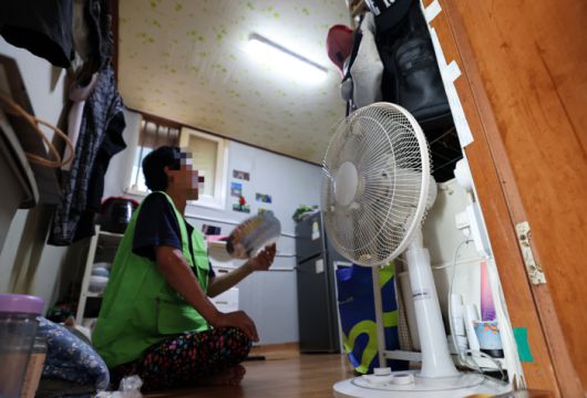 서울 영등포구에 있는 쪽방촌에 거주하는 한 시니어가 2평 남짓한 쪽방에서 부채질을 하고 있다. [이충우 기자]