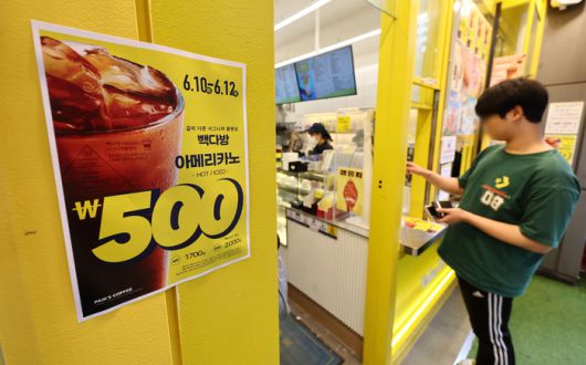 더본코리아의 커피전문점 빽다방이 아이스 아메리카노와 핫 아메리카노를 500원에 판매하는 할인 행사를 시작한 지난달 10일 서울 시내의 한 빽다방 매장 앞에 할인 안내문이 붙어있다. [사진 = 연합뉴스]