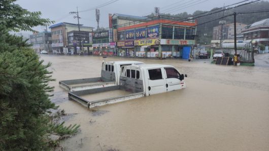 세종지역에 이틀간 200~300mm가 넘는 많은 비가 내리면서 17일 오전 조치원 신안리 일대를 지나는 1번국도 일부 구간이 물에 잠겼다. 도로변 공터에 주차된 차가 빗물 속에 그대로 남겨져 있다. [사진 = 연합뉴스]