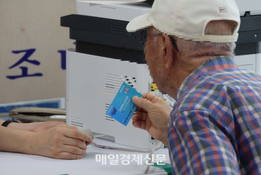 민생회복 소비쿠폰 1차 신청 첫 날인 21일 서울 동작구 사당1동주민센터를 찾은 시민들이 민생회복 소비쿠폰을 신청하고 있다. [한주형기자]