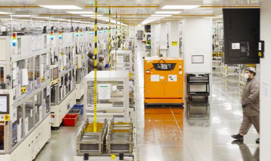 자동화 물류 설비가 부품을 운반하는 가운데 SKBA 근로자가 Z폴딩 스태킹 공정 등이 이뤄지는 조립 장비를 살펴보고 있다. [사진 = SK온]