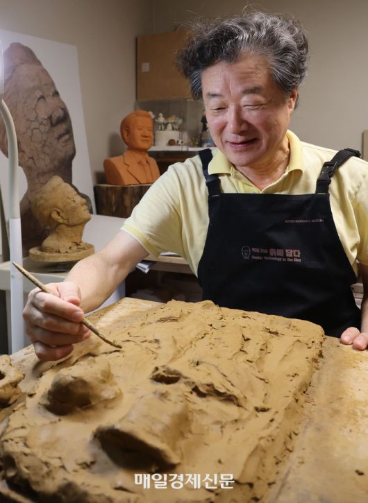 서울 용산구 서빙고동 자택의 작업실에서 흙 작품을 만들고 있는 김준규 전 검찰총장. 왼쪽 작품이 그가 가장 아끼는 자소상 ‘메멘토 모리’다. <이승환 기자>