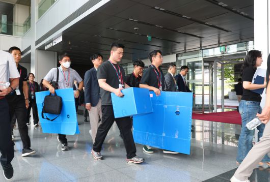 경기남부경찰청과 고용노동부 관계자들이 경기도 광명시 포스코이앤씨 고속도로 건설공사 현장의 미얀마인 근로자 감전 사고와 관련해 12일 포스코이앤씨 인천 본사(인천 연수구) 압수수색을 위해 사옥으로 들어가고 있다.  지난 4일 경기도 광명시 광명∼서울고속도로 연장공사 현장에서 미얀마 국적의 30대 남성 근로자가 지하 물웅덩이에 설치된 양수기 펌프를 점검하다 감전으로 추정되는 사고를 당해 현재까지 의식을 되찾지 못하고 있다. [사진 = 연합뉴스]