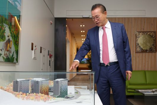 문주현 엠디엠 회장이 조감 모형을 가리키고 있다. [한주형 기자]