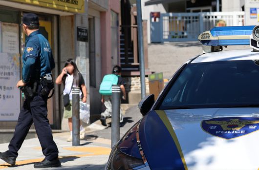 초등학교 인근 유괴 미수와 불법 촬영 사건 등으로 학부모들의 불안감이 확산하는 가운데 10일 오후 서울 서대문구의 한 초등학교 정문 앞에서 경찰관이 학생들의 하교를 지켜보고 있다. [뉴스1]