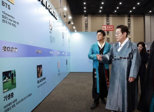 K컬처 체험존 관람하는 이재명 대통령과 박진영 공동위원장.  사진ㅣ연합뉴스