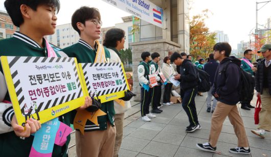 지난 10월 29일 오전 인천시 연수구 송도동 연송고등학교 앞에서 학생들이 ‘전동킥보드 안전수칙 캠페인’을 벌이고 있다.  같은 달 18일 송도동 한 인도에서 중학생 2명이 타고 달리던 전동킥보드에 30대 여성이 치여 중태에 빠졌다. <연합뉴스>