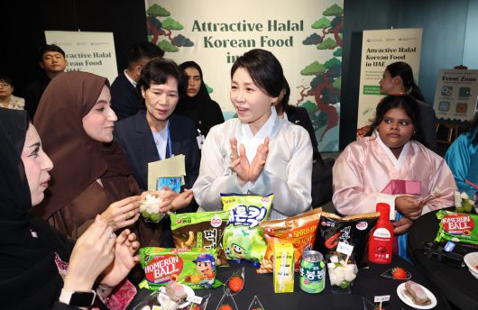 이재명 대통령의 아랍에미리트(UAE) 국빈 방문에 동행한 김혜경 여사(가운데)가 '할랄 K푸드' 홍보에 직접 나서며 문화 교류의 핵심 보조축 역할을 하고 있다. 김 여사는 연한 옥빛이 도는 한복을 입고 행사장에 도착해 한국 업체가 UAE 현지에서 생산하는 딸기를 맛보는 등 K푸드 홍보에 앞장섰다. 사진은 김 여사가 19일 아부다비의 한 호텔에서 열린 할랄 인증 K푸드 홍보행사에서 참석자들과 이야기를 나누는 모습. 아부다비 김호영 기자