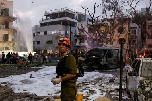 16일(현지시간) 이스라엘 텔아비브에서 이란 미사일 공격에 피해를 입은 주거지 일대를 구조대원들이 수습하고 있다. <로이터 연합뉴스>