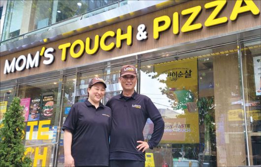 강재구 맘스터치 3개 점주(오른쪽)가 아내와 함께 맘스터치 대치사거리점 앞에서 포즈를 취하고 있다. (맘스터치 제공)