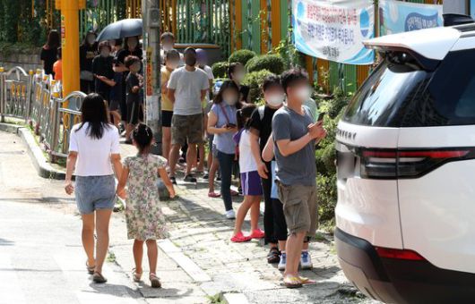 23일 경기 김포시의 한 선별진료소에 학무모와 아이들이 검사를 받기 위해 줄지어 서 있는 모습. 뉴스1