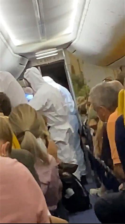 비행기 이륙 직전 코로나 확진 판정을 받은 승객을 보호복을 입은 의료진이 데려가고 있다. [트위터 캡처]