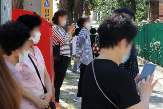 수도권의 유치원과 초·중·고등학교 등교가 재개된 21일 오전 서울 강동구 한산초등학교 교문 앞에서 학부모들이 수업을 마친 학생들을 기다리고 있다. 뉴스1