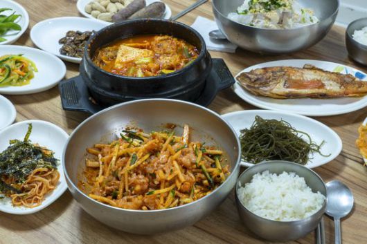 방어진항 횟집 골목에서 흔히 볼 수 있는 가자미 물회(1만5000원) 상차림. 고추장, 밥과 함께 비빈 뒤 취향에 따라 물을 부어 가며 먹는다. 매운탕과 불볼락 구이가 깔렸다.