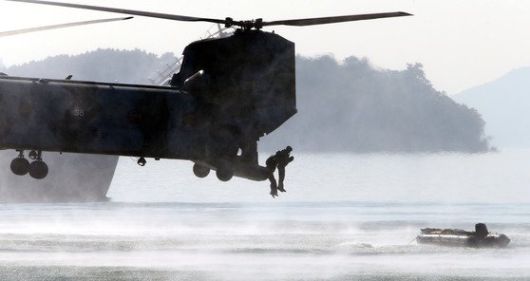 해군 특수전전단(UDT/SEAL) 대원들이 지난 2015년 창설 60주년을 기념해 해군작전사령부 진해기지에서 특수전 훈련을 시연하고 있다. 대원들이 침투용 고무보트에 타기 위해 대형수송헬기에서 해상으로 뛰어내리고 있다. [중앙포토]