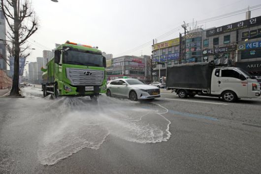 전국 대부분 지역에서 미세먼지 농도 '나쁨' 수준을 보인 15일 오전 광주 북구 운암동 한 도로에서 북구청 환경과 기후변화대응팀 직원들이 미세먼지 절감을 위해 살수차로 물을 뿌리고 있다. 뉴스1