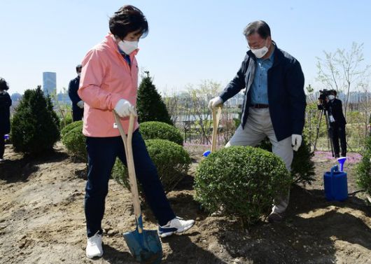 문재인 대통령과 김정숙 여사가 5일 마포구 서울복합화력발전소에서 열린 제76회 식목일 기념행사에서 학생들과 나무를 심고 있다. 청와대사진기자단