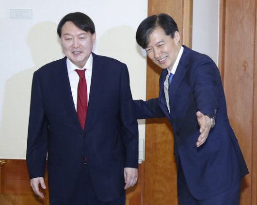 2019년 7월 25일 조국 당시 청와대 민정수석이 윤석열 당시 검찰총장 임명장 수여식 전 열린 차담회에서 윤 전 총장에게 자리를 안내하고 있는 모습. 여권 지지자들은 “윤석열 전 총장 가족은 조국 전 법무부 장관 가족처럼 검증을 받아야 한다”고 주장하고 있다. 연합뉴스