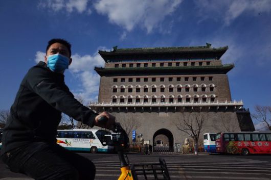 지난해 3월 신종 코로나바이러스 감염증에 따른 봉쇄 조치 등으로 중국의 대기오염이 크게 감소한 가운데 마스크를 착용한 시민이 베이징 치안먼(前門) 지구의 전탑(箭塔) 근처를 자전거로 이동하고 있다. EPA=연합뉴스