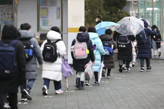 지난달 25일 오전 개학을 맞은 서울의 한 초등학교에서 학생들이 거리두기를 하며 등교하고 있다. [연합뉴스]