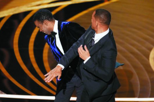 윌 스미스가 시상식 도중 무대에서 자신의 아내를 두고 농담한 배우 크리스 록의 뺨을 때리고 있다. [AP=연합뉴스]