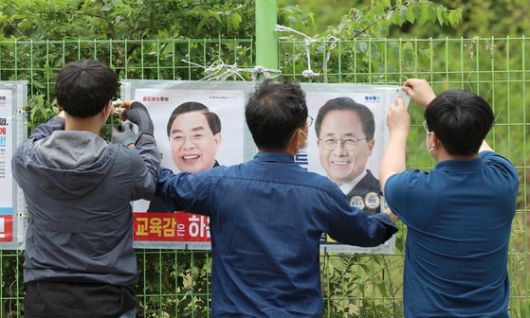 제8회 전국동시지방선거 공식 선거운동 첫날인 19일 부산시 수영구 망미1동 행정복지센터 부근에서 수영구 직원들이 교육감 선거벽보를 부착하고 있다. 뉴스1