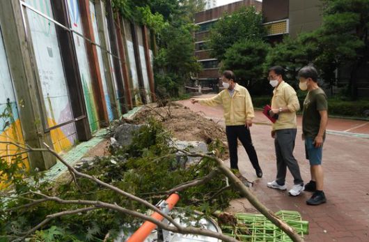 조희연 서울교육감(왼쪽)이 지난 8월 11일 오후 집중호우로 피해를 입은 서울 동작구 국사봉중학교를 찾아 현장 상황을 살펴보고 있다. 뉴스1