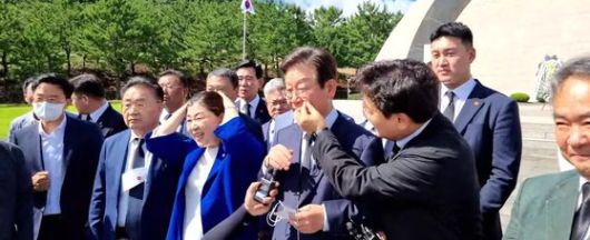 지난 2022년 8월 제주도 제주 4·3 평화공원에서 박찬대 더불어민주당 의원이 이재명 당시민주당 대표 후보의 광대뼈에 묻은 이물질을 떼는 모습. 사진 유튜브 채널 ‘정치타파TV’ 캡처