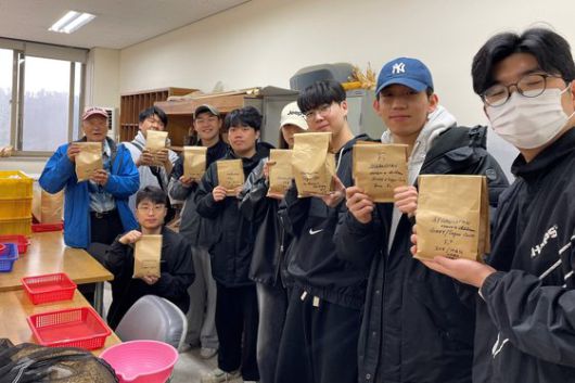 국제옥수수재단 이사장 김순권 박사와 학생들이 아프가니스탄에 보낼 종자를 손에 들고 포즈를 취하고 있다.