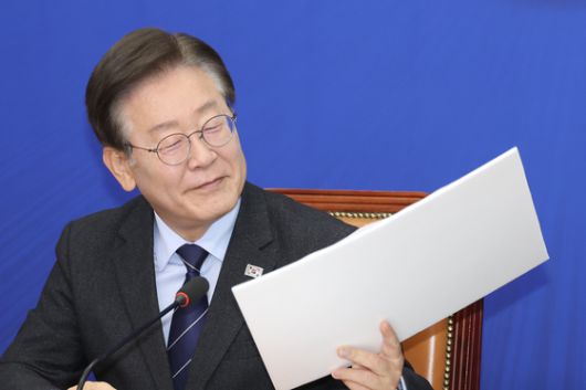 이재명 더불어민주당 대표가 지난해 6월10일 오전 서울 여의도 국회에서 열린 최고위원회의에 참석해 장경태 최고위원이 준비한 김성태 쌍방울 전 회장 전과 내역, 주가조작 의혹 관련 자료를 보고 있다. 전민규 기자