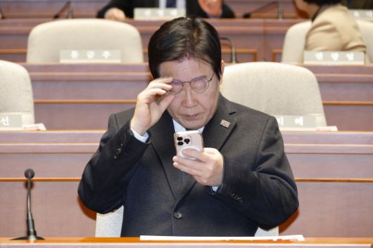 이재명 더불어민주당 대표가 지난해 12월 27일 오후 서울 여의도 국회에서 열린 의원총회에 참석해 휴대전화를 살피고 있다. 뉴스1