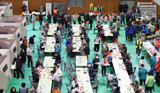 경북 청송군 산불 피해 이재민 대피소에서 30일 이재민들이 식사 중이다. 청송군민들이 이곳에서 숙식한 것은 이날로 엿새째다. [연합뉴스]