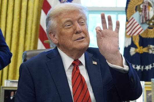 도널드 트럼프 미국 대통령이 17일(현지시간) 백악관 집무실에서 행정 명령에 서명하다 손가락으로 제스처를 취하고 있다. 보기에 따라 '동전'을 의미하는 것으로도 해석된다. AP=연합뉴스