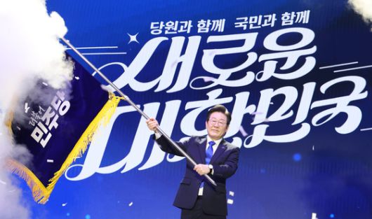 지난해 8월 18일 이재명 당시 더불어민주당 대표가 서울 송파구 KSPO DOME(올림픽체조경기장)에서 열린 전당대회에서 대표 연임에 성공한 뒤 당기를 받아 흔들고 있다. 전민규 기자