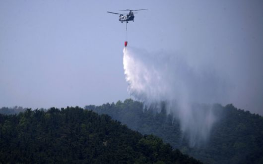 대구 북구 함지산 산불 이틀째인 29일 오후 산불 진화 작전에 투입된 군용 헬기가 함지산 상공에서 물을 뿌리고 있다. 뉴스1