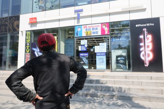 2일 서울 시내의 한 SK텔레콤 대리점 앞에서 한 소비자가 유심 재고 소진 안내문을 한참 바라보고 있다. 연합뉴스