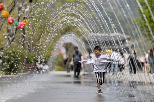 서울 낮 최고기온이 26도를 기록하는 등 초여름 날씨를 보인 지난달 21일 서울 세종대로 광화문광장 터널 분수에서 어린이가 더위를 식히고 있다. 뉴스1