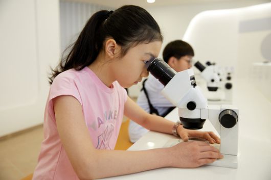 현미경을 통해 유산균을 관찰하는 소중 학생기자단.