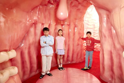 박준후 학생기자·임서희 학생모델·김산하(왼쪽부터) 학생기자가 입과 위, 장을 재현해 놓은 방에 들어가 유산균이 어떤 역할을 하는지 체험했다.