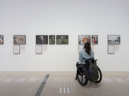 알레시아 네오의 '돌봄 색인: 돌봄의 무보(舞譜)'를 보는 관람객. 전시 작품은 눈높이를 맞춰 걸었고 바닥에 점자 블록을 설치했다. 사진 국립현대미술관