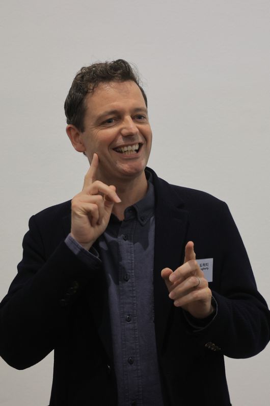 '농인공간: 입을 맞추는 의자'를 만든 미국의 건축가 리처드 도허티가 수어로 작품을 설명하고 있다. 그의 영어 수어는 수어 통역사의 입으로 발화됐고, 영-한 통역사가 우리말로 옮기면 한국어 수어 통역사가 다시 전달했다. 연합뉴스